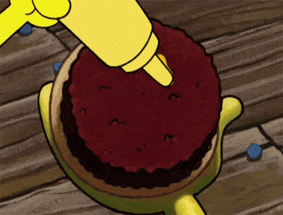 A Cartoon Character Is Icing A Cake With A Yellow Piping Bag GIF