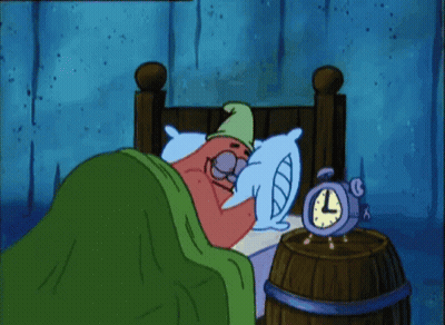 A Cartoon Character Is Laying In Bed Next To An Alarm Clock That Reads 3:00 GIF