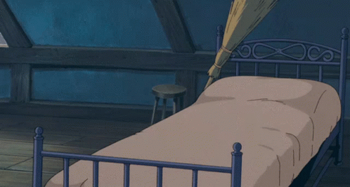 A Cartoon Character Is Laying On A Bed With A Broom Hanging From The Ceiling GIF