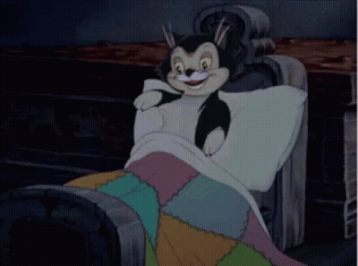 A Cartoon Character Is Laying On A Couch With A Blanket On . GIF