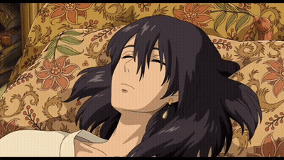 A Cartoon Character Is Laying On A Couch With A Floral Blanket GIF
