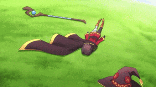 A Cartoon Character Is Laying On The Grass With A Staff And A Witch Hat . GIF