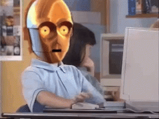 A Cartoon Character Is Sitting At A Desk In Front Of A Computer GIF