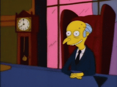 A Cartoon Character Is Sitting At A Table With A Clock Behind Him GIF