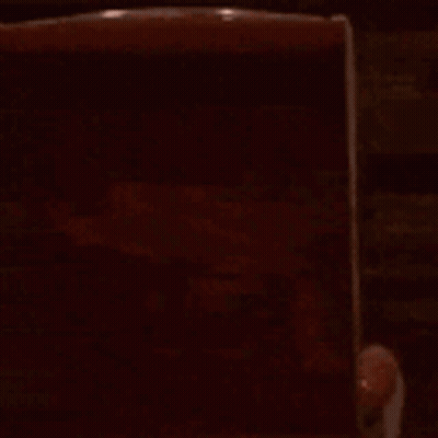 A Cartoon Character Is Sitting In A Chair In A Dark Room Watching A Movie . GIF