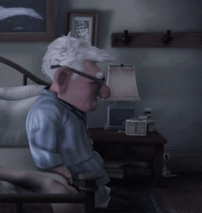 A Cartoon Character Is Sitting In A Chair With A Lamp And A Clock On The Table GIF