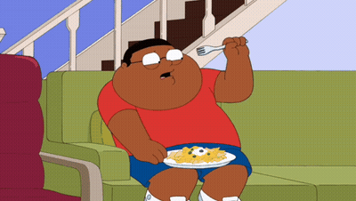 A Cartoon Character Is Sitting On A Couch Eating A Plate Of Food GIF