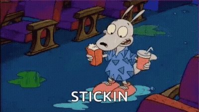 A Cartoon Character Is Sitting On The Floor With A Drink And A Book . GIF