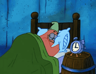 A Cartoon Character Is Sleeping In A Bed Next To An Alarm Clock That Says L On It GIF