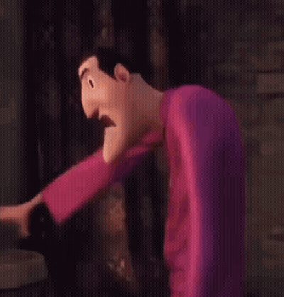 A Cartoon Character Is Standing In Front Of A Brick Wall And Making A Funny Face . GIF