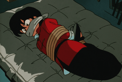 A Cartoon Character Is Tied Up On A Bed And Has A Bandage On His Face GIF
