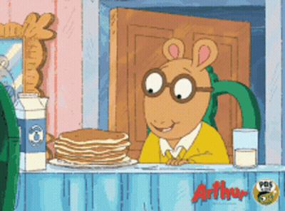 A Cartoon Character Named Arthur Sits At A Counter With Pancakes And Milk GIF