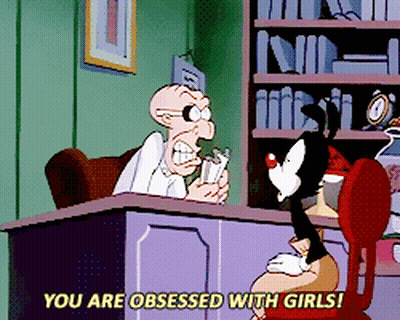A Cartoon Character Says " You Are Obsessed With Girls " While Sitting At A Desk GIF