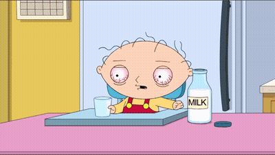 A Cartoon Character Sitting At A Table With A Bottle Of Milk Next To Him GIF