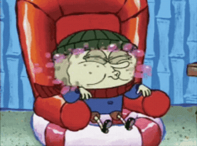 A Cartoon Character Sitting In A Chair With Bubbles Coming Out Of His Eyes GIF