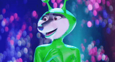 A Cartoon Character Wearing A Green Alien Costume Is Standing In Front Of A Blurry Background . GIF