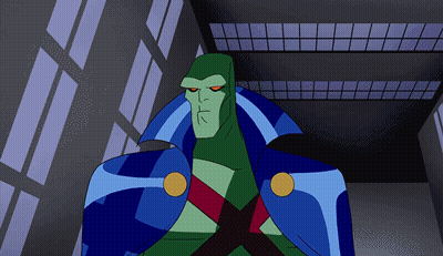 A Cartoon Character With A Blue Cape And Red Eyes Stands In Front Of A Building GIF