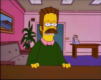 A Cartoon Character With A Green Sweater And A Mustache Is Sitting At A Desk GIF
