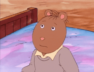 A Cartoon Character With A Mouse Head Is Sitting On A Bed With His Hand To His Chin GIF