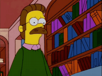 A Cartoon Character With A Mustache Stands In Front Of A Bookshelf Full Of Books GIF