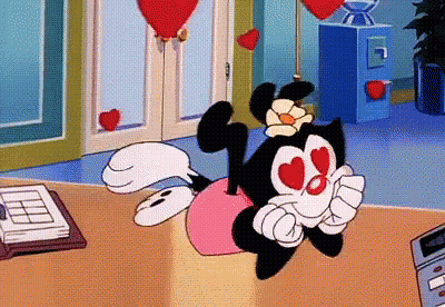 A Cartoon Character With Hearts In Her Eyes Is Laying On A Table GIF
