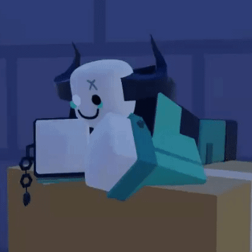 Horned Cartoon Character Laying On Table With Laptop GIF