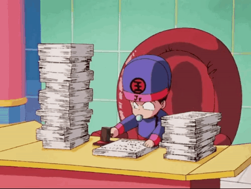 A Cartoon Character With Jr On His Hat Sits At A Desk With Stacks Of Papers GIF