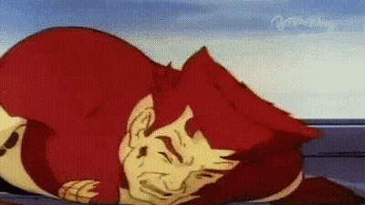 A Cartoon Character With Red Hair Is Laying On The Ground With His Eyes Closed . GIF