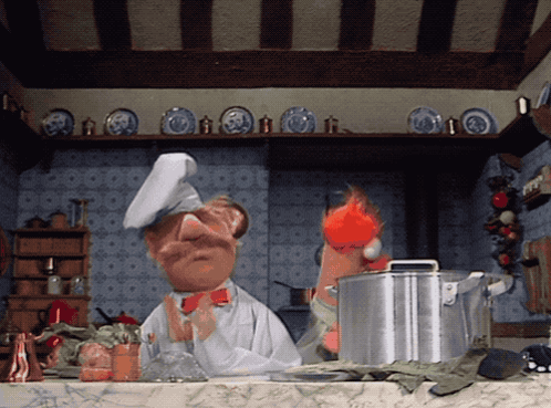 A Cartoon Chef Is Standing In A Kitchen With Plates On The Shelf GIF