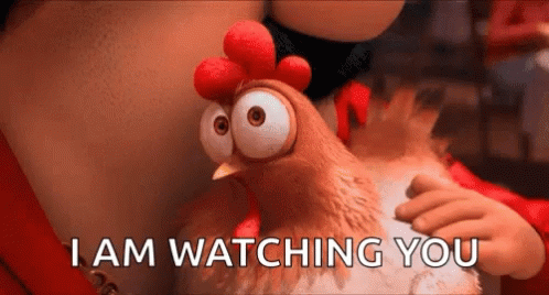 A Cartoon Chicken With Big Eyes Is Being Held By A Person . GIF