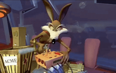 A Cartoon Coyote Is Playing A Video Game In Front Of A Box That Says Acme GIF