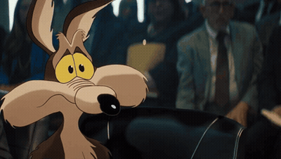 A Cartoon Coyote Is Sitting In A Car Looking At The Camera GIF