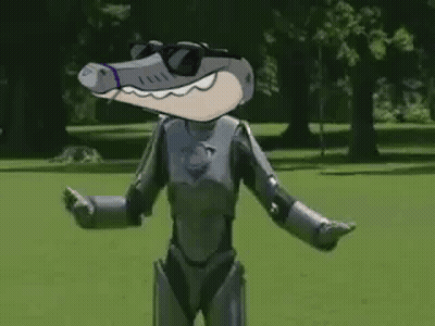 A Cartoon Crocodile In A Robot Costume Is Standing In A Park With His Arms Crossed . GIF