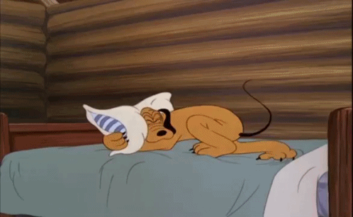 A Cartoon Dog Is Sleeping On A Bed With A Pillow In Its Mouth . GIF