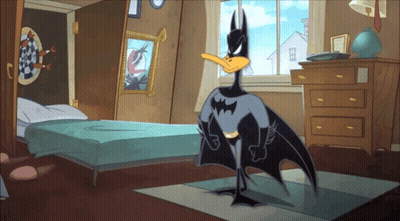 A Cartoon Duck Dressed As Batman Is Standing In A Bedroom GIF