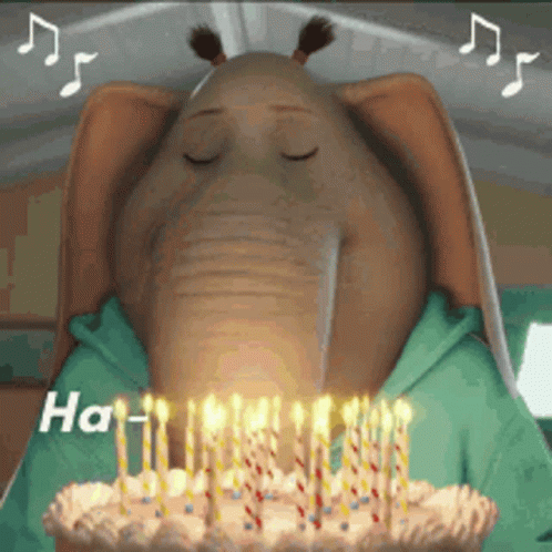 A Cartoon Elephant Blowing Out Candles On A Cake GIF