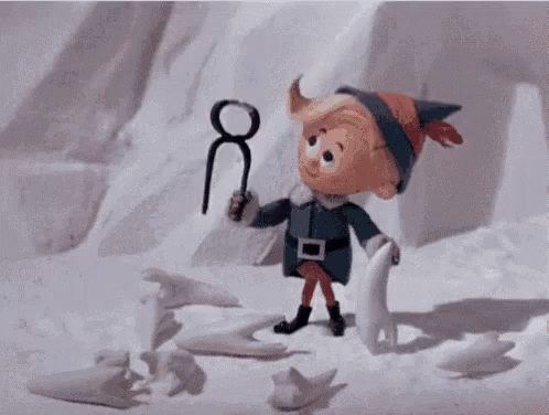 A Cartoon Elf Is Holding A Pair Of Scissors In His Hand . GIF