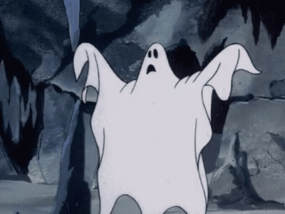 A Cartoon Ghost With A Surprised Look On His Face Is Standing In Front Of A Rock Wall . GIF
