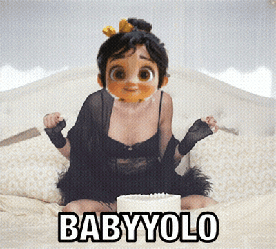 A Cartoon Girl Is Sitting On A Bed With A Cake And The Words Babyyolo GIF