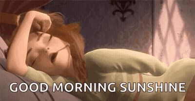 A Cartoon Girl Is Sleeping On A Bed With The Words `` Good Morning Sunshine '' Written Above Her . GIF