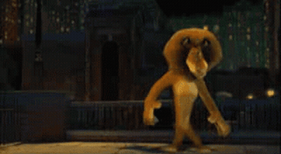 A Cartoon Lion Is Standing In Front Of A City At Night GIF