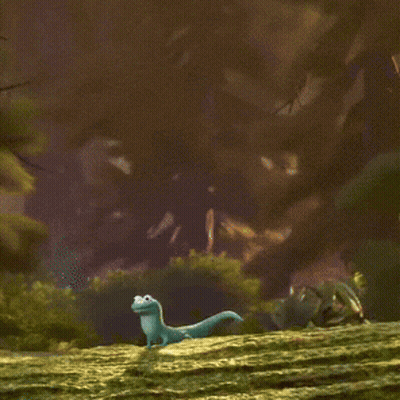 A Cartoon Lizard Is Sitting On A Grassy Hill And Smiling GIF