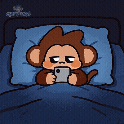 A Cartoon Monkey Is Laying In A Bed Looking At A Cell Phone GIF