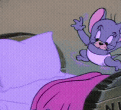 A Cartoon Mouse Is Sitting On A Bed With Purple Sheets GIF