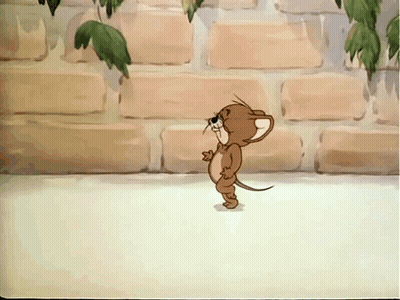 A Cartoon Mouse Is Standing In Front Of A Brick Wall With Leaves Hanging From It GIF