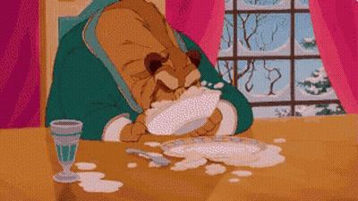 A Cartoon Of A Bear Sitting At A Table Eating Food GIF