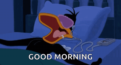 A Cartoon Of A Duck Laying On A Bed With The Words Good Morning Above Him GIF
