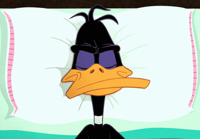A Cartoon Of A Duck Laying On A Pillow With His Eyes Closed GIF