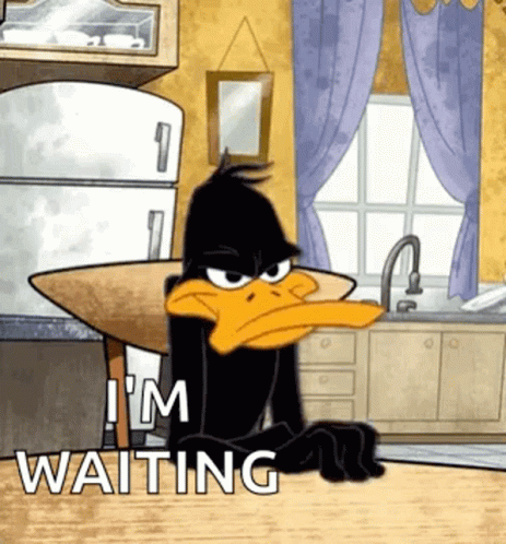 A Cartoon Of A Duck Sitting At A Table In A Kitchen With The Words `` I 'M Waiting '' . GIF