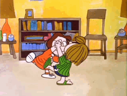 A Cartoon Of A Girl Kissing Another Girl In A Living Room . GIF